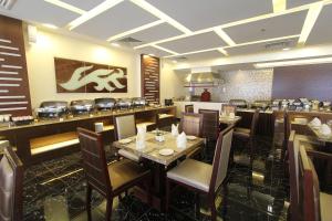 a restaurant with a dining room with tables and chairs at Ivory Grand Hotel Apartments in Dubai