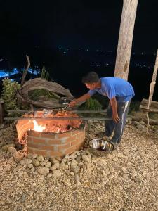 Ein Mann bereitet Essen über einem gemauerten Ofen zu. in der Unterkunft Laeley 1,000 miles resort in Ko Lanta Yai