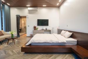 a bedroom with a bed and a living room at Lake House Ha Giang in Ha Giang