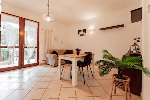 een woonkamer met een tafel en stoelen bij Trilocale con giardino a Cervia - CV012 in Cervia +10 foto's