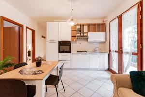 een keuken en woonkamer met een tafel en stoelen bij Trilocale con giardino a Cervia - CV012 in Cervia