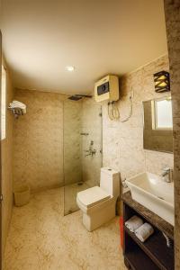 een badkamer met een toilet, een wastafel en een douche bij The Ruby Resort Vrindavan # Prime Location # Luxury Rooms # Near Prem Mandir # Restaurant # Big Lawn # Big Parking # By Nandan Group # in Vrindāvan