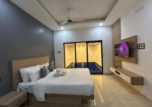 a bedroom with a large bed and a window at Sarang Resort Varkala by VOYE HOMES - Includes Rooms with Private Pool in Varkala