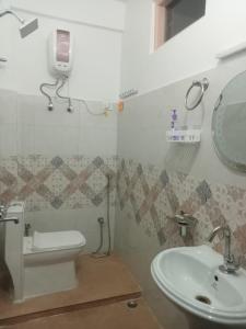 ein Badezimmer mit Waschbecken, Toilette und Spiegel in der Unterkunft Pines Heaven Homestay in Kalimpong + 1 Foto
