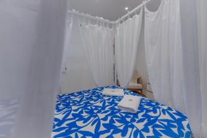 a bedroom with a blue and white bed with curtains at Évasion Santorin - Jacuzzi & Relax in Le Havre