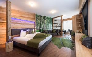 a bedroom with a large bed and a living room at Aurina Lodges in Lutago