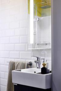 Baño blanco con lavabo y espejo en King Street Design Apartment for 12, en Budapest