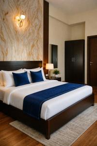 een slaapkamer met een groot bed met blauwe kussens bij The Ruby Resort Vrindavan # Prime Location # Luxury Rooms # Near Prem Mandir # Restaurant # Big Lawn # Big Parking # By Nandan Group # in Vrindāvan