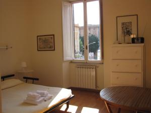 a bedroom with a bed and a table and a window at Casa Castelbolognese in Rome