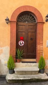 een houten deur met een rode strik erop bij Casa Rasiglia 2 in Casenove