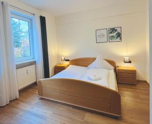 a bedroom with a large bed and a window at Pension Lutter in Bodenwöhr