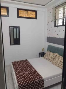 a bedroom with a bed and two windows at La jarrie land in Mandanou