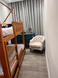 a bedroom with two bunk beds and a chair at Chácara Coração no Mato in Santa Isabel +31 photos