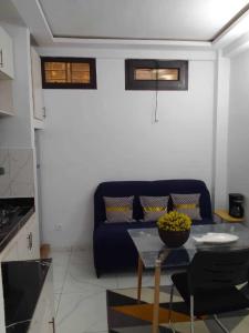 a living room with a blue couch and a table at La jarrie land in Mandanou