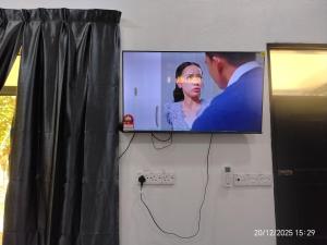 a flat screen tv hanging on a wall at Moksu Garden Tiny House jerteh in Jertih
