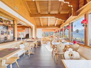 ein Restaurant mit Tischen, Stühlen und Fenstern in der Unterkunft Bergblick Lodge - 3 Sterne Garni - Neueröffnung in Aeschi