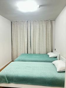 due letti uno accanto all'altro in una camera da letto di Dino a Dalandzadgad