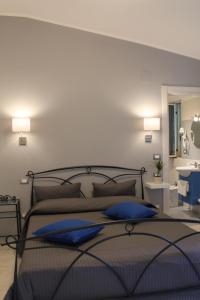 a bedroom with a large bed with blue pillows at Sea Garden Rooms in Termoli