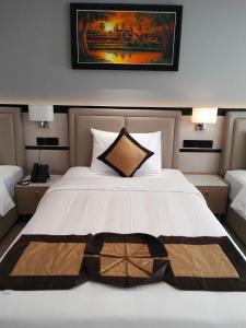 una camera da letto con un grande letto bianco con un dipinto sul muro di LN hotel&Residence a Phumĭ Prêk Chrey