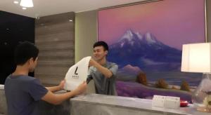 two men standing at a counter holding a piece of paper at Lavande Hotel Guangzhou Tianhe Sports West Road Subway Station in Guangzhou