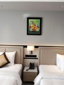 a hotel room with two beds and a picture on the wall at LN Hotel & Residence in Phumĭ Prêk Chrey