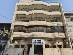een hoog gebouw met een bord ervoor bij Sant-I Hotel in Kānpur