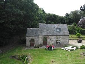 a small stone house with a table and chairs at maison kerivarch G in Saint-Pol-de-Léon