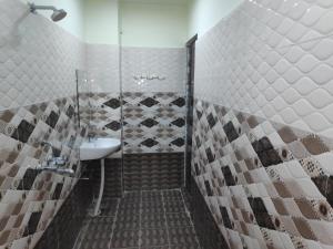 een badkamer met een douche en een wastafel bij Sant-I Hotel in Kānpur