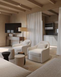 a living room with two chairs and a table at Salt Suites Paros in Naousa