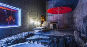 a bathroom with a tub and a red umbrella at Qingdao Hengbo Hotel in Qingdao