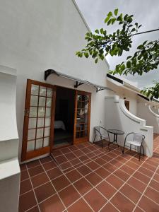 eine Terrasse mit Tisch und Stühlen in einem Gebäude in der Unterkunft Wingrock Guesthouse in George + 14 Fotos