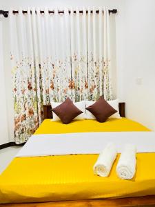 a bedroom with a yellow bed with a curtain at Moon View Homestay in Kamburugamuwa