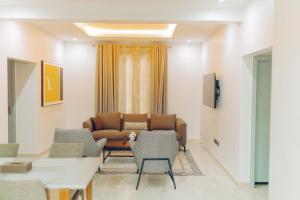 ein Wohnzimmer mit Sofa, Tisch und Stühlen in der Unterkunft Elysium Suites & Apartments in Accra