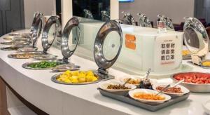 a buffet with many plates of food on a table at Wenxing Hotel Guangzhou Gangding Metro Station Branch in Guangzhou