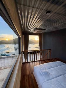 a bedroom with a bed and a large window at Rock Bay by Chành Rành in Vĩnh Hy