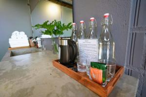 a wooden tray with four glass bottles on a table at Rock Bay by Chành Rành in Vĩnh Hy