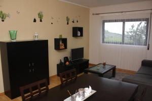 a living room with a table and a couch at Apartamento Mar e Sol in Ponta Delgada