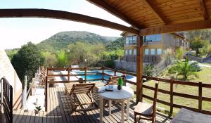 a patio with a table and chairs and a pool at Balcon de los Molles in Santa Rosa de Calamuchita