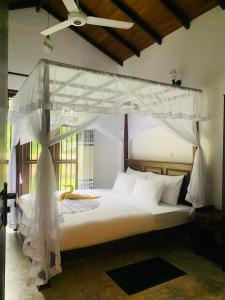 a bedroom with a bed with a canopy at Aaryana Lagoon in Tangalle +42 photos