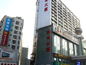 ein hohes Gebäude mitten in einer Stadt in der Unterkunft Sheng Lin Na Hotel Minzhi Branch in Shenzhen