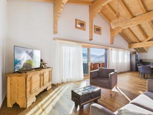 ein Wohnzimmer mit Fernseher, Couch und Sesseln in der Unterkunft Bergblick Lodge - 3 Sterne Garni - Neueröffnung in Aeschi
