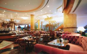 a restaurant with tables and chairs in a building at Grand Metropark Hotel Nanjing in Nanjing