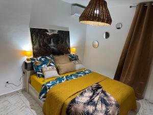ein Schlafzimmer mit einem Bett mit einer gelben Decke in der Unterkunft Aqua longe Saint-François in Saint-François