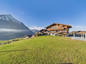 ein Haus auf einer grünen Wiese mit einem Berg in der Unterkunft Bergblick Lodge - 3 Sterne Garni - Neueröffnung in Aeschi