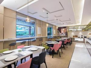 a restaurant with tables and chairs and a bar at Magnotel Shanghai Maglev Station in Shanghai