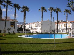 a resort with a swimming pool and palm trees at salobreña primera linea de playa in Salobreña