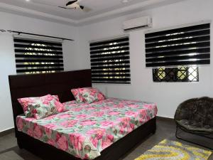 AvenawMiky Hillside Lodge的一间卧室配有一张带粉红色床单和窗户的床。