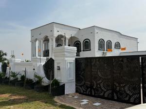 AvenawMiky Hillside Lodge的一栋白色的房子，大门是黑色的 更多19张照片