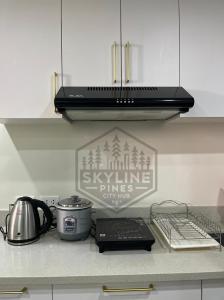 eine Küchentheke mit Herdplatte und einem Schild in der Unterkunft Skyline Pines City Hub - Baguio in Baguio City