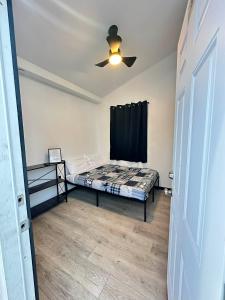 een slaapkamer met een bed en een plafondventilator bij Adventure Trail Cabin #9 in Houston